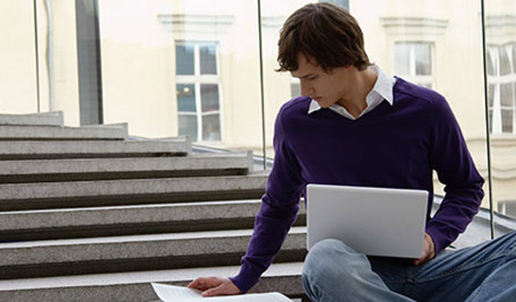 Student with laptop on stairs