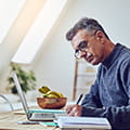 Man in Sweater Writes Longhand 