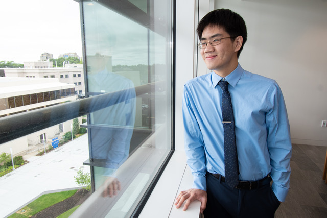 Image of young entrepreneur Michael Lai standing near window and looking out of it